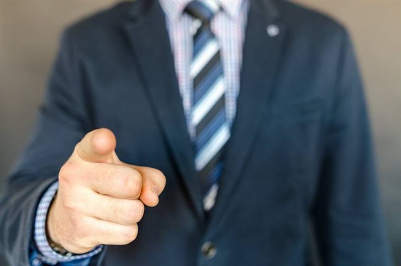 man in a suit pointing his finger at you