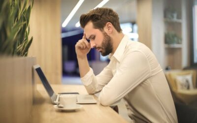 man looking at laptop trying figure out a problem