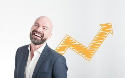 happy man standing in front of yellow arrow pointing up